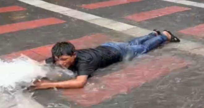 Sokakta biriken suda çocuğun gülümseten eğlencesi