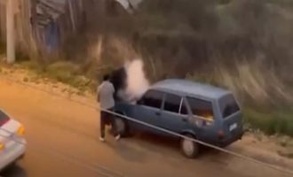 Alev alev yanan aracını kovayla su döküp söndürdü